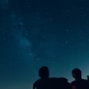 Two heads are silhouetted against a blue starry sky.