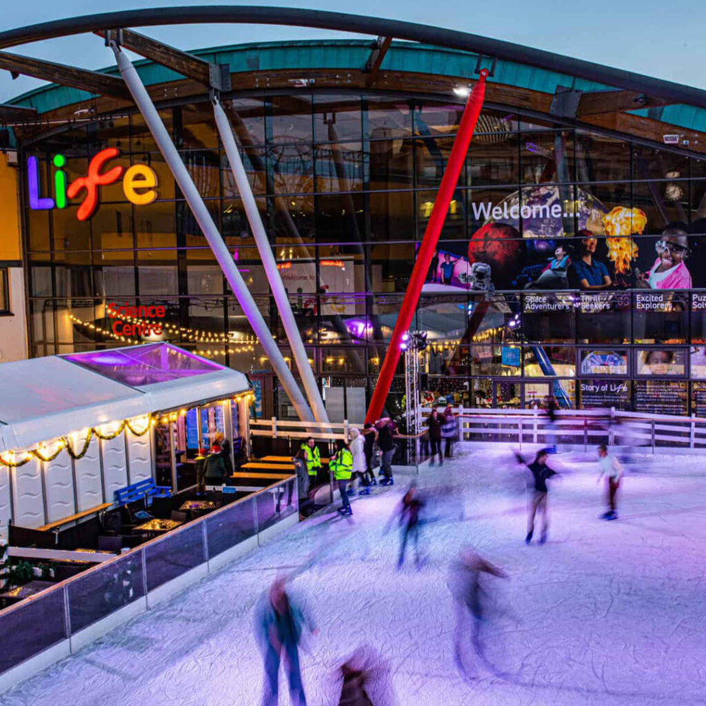 People ice skate on the rink outside of the Life Science Centre.