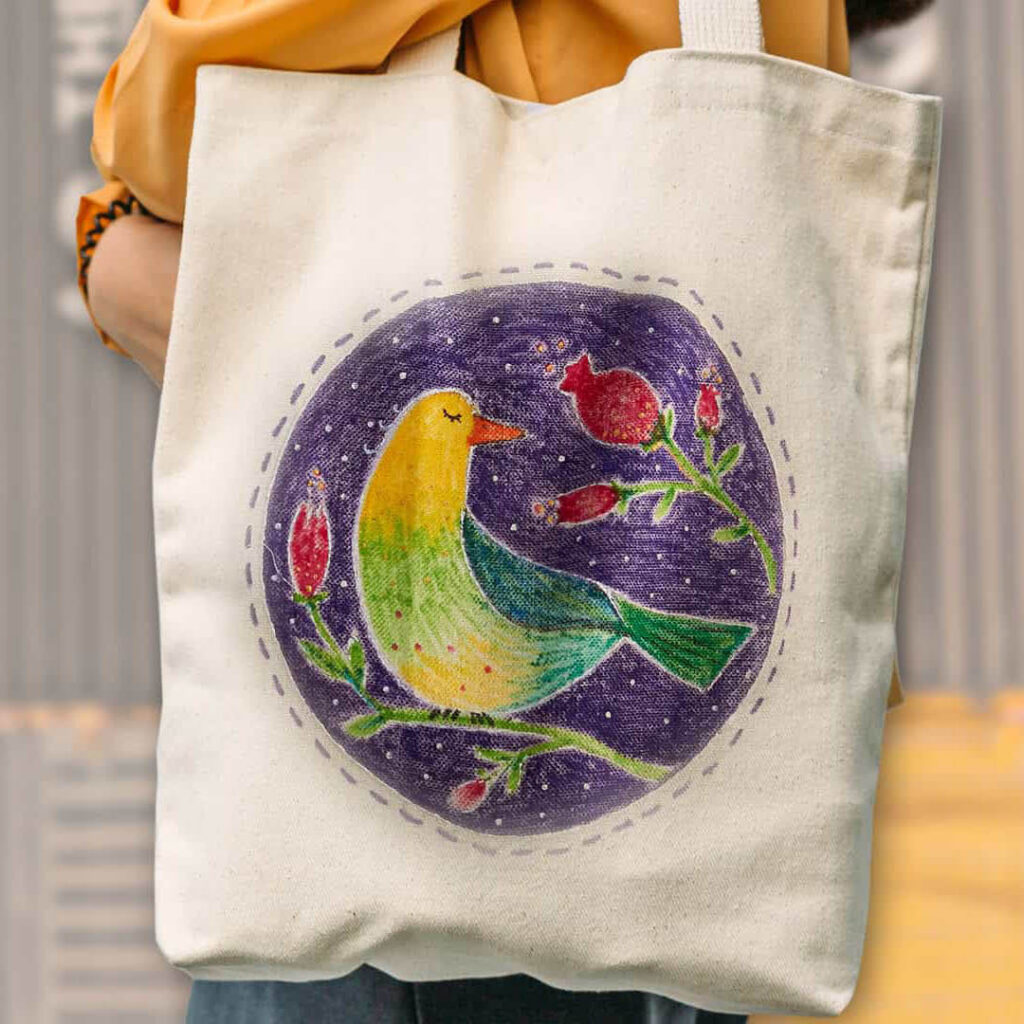 A tote bag with a hand drawn design. It shows a tropical bird with a flower.