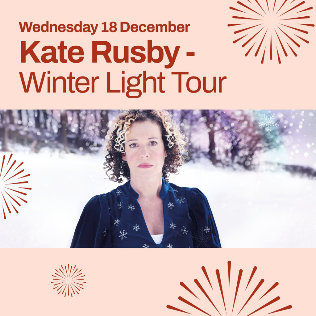Kate Rusby, a white woman with short curly hair, stands in a snowy field with snow falling around her. She looks at the camera with a forlorn expression. Above this image, red text says: Kate Rusby, Winter Light Tour.