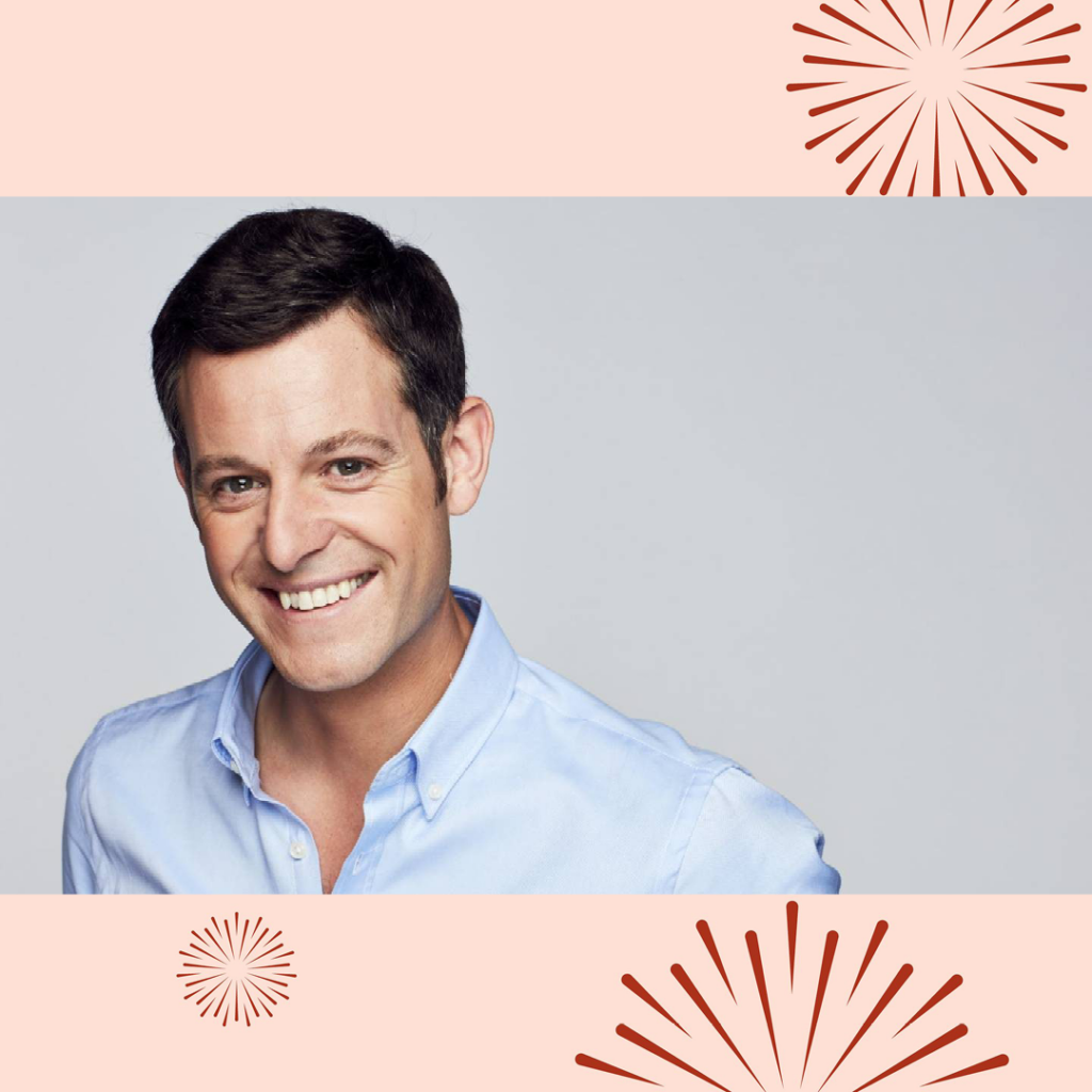 Matt Baker, a white man with dark brown hair, wears a pale blue shirt. He stands against a grey background and grins at the camera.