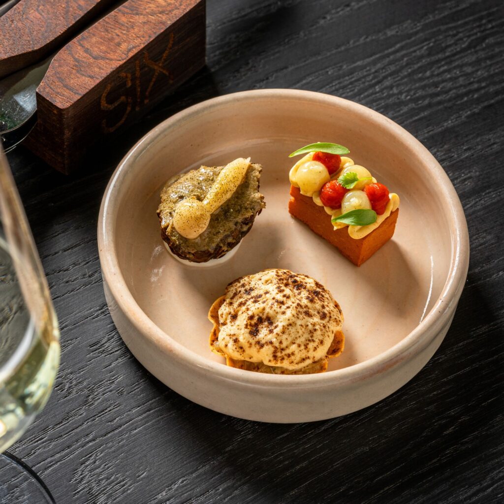 A plate of food is served at SIX baltic, their vegan tasting menu features fresh ingredients and flavourful combinations.