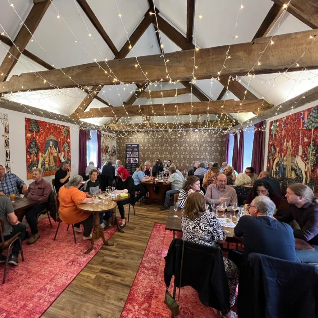 Tables of people sit under the beamed roof of Blackfriars restaurant, which is strung with fairy lights. They are taking part in the quiz night at Blackfriars Restaurant.