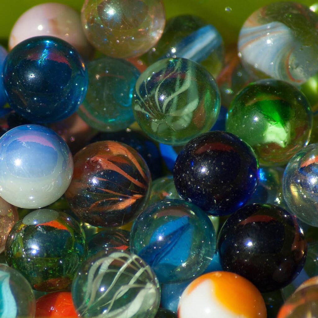 A pile of glass marbles with different colours and swirls.