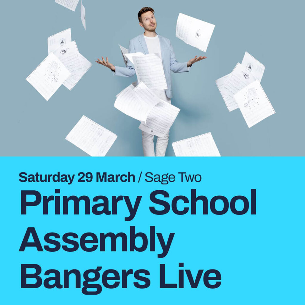John B Partridge, a white man in a pale blue blazer and white jeans, shrugs as school exam papers fall around him. A bright blue strip below the image features the words: Primary School Assembly Bangers Live. Saturday 29 March.
