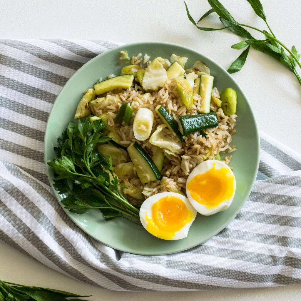 A bowl of eggs and vegetables is plated on the kitchen counter