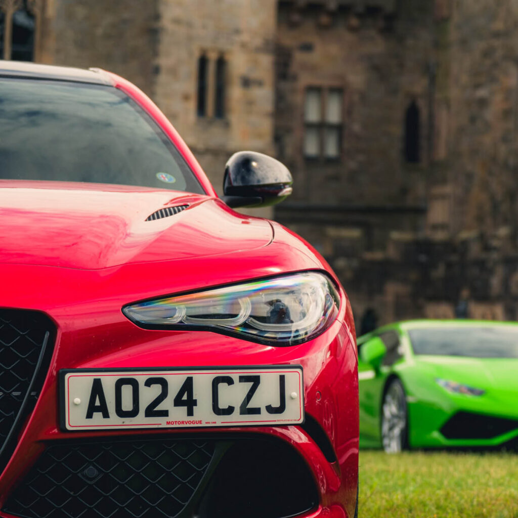 A red car and a green sports car. They are being displayed at the Auto Italia Car Day at Raby Castle.