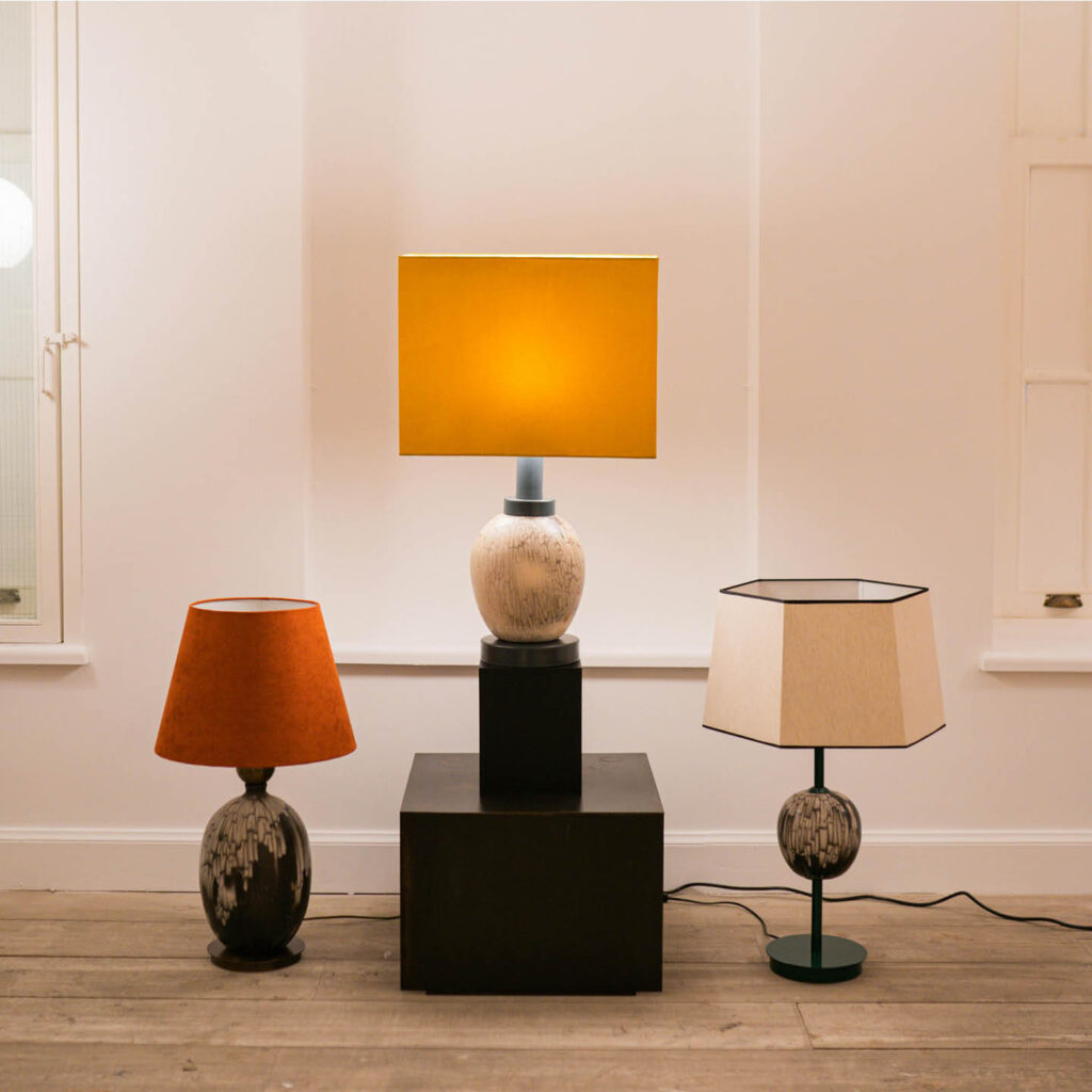 Three lamps with different shades in red, orange and white.