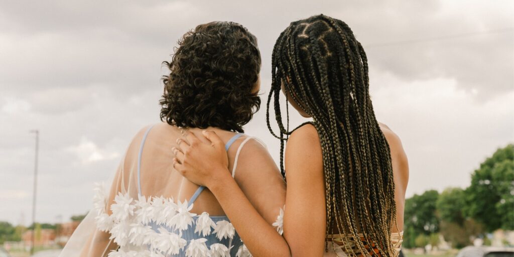 Two friends side hugging looking into the distance