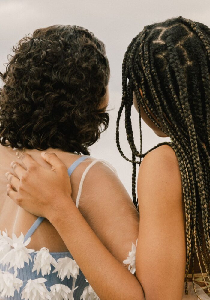 Two friends side hugging looking into the distance