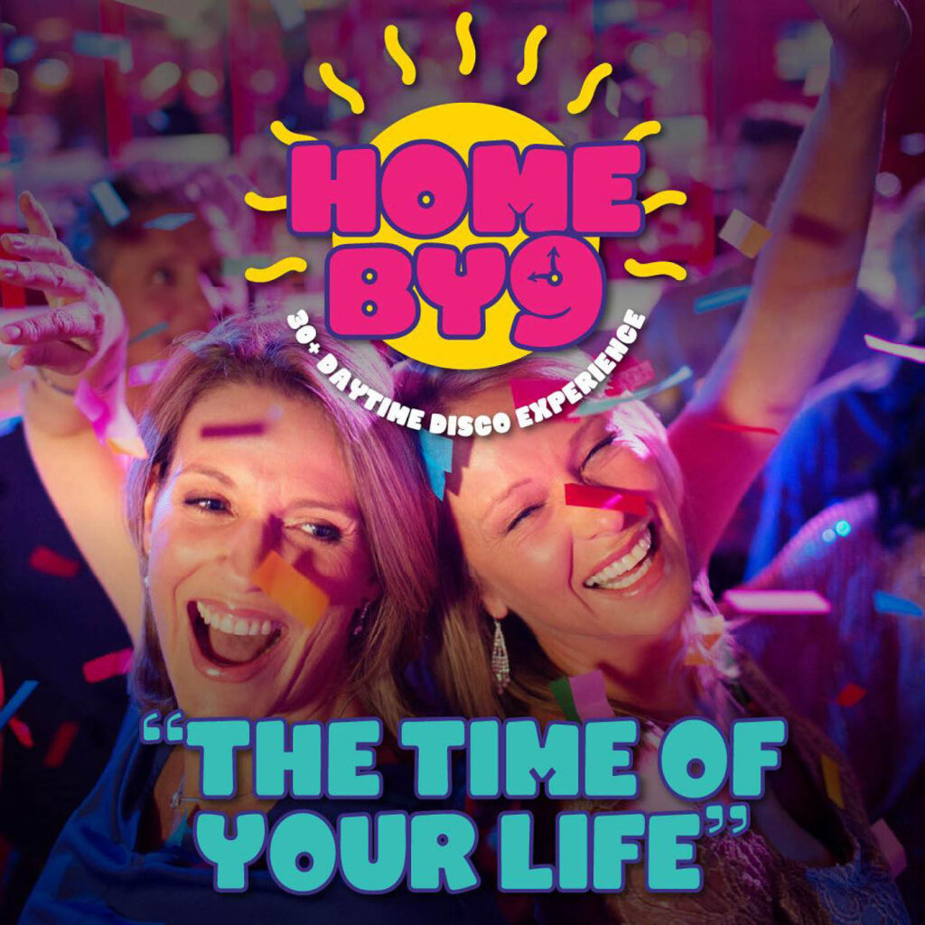 Two women grin widely as they dance next to each other, confetti falling around them. Bright pink text is overlaid on a yellow sun above them. It says: Home by 9. Beneath them, blue text reads: The Time of Your Life.