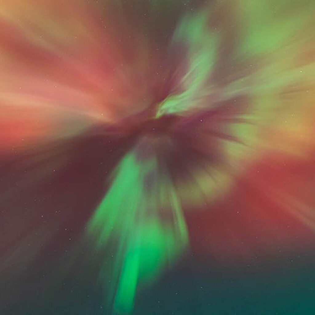 A beautiful image depicting the reds, greens and purples of space. This is a piece of light-inspired artwork that guests can create at the Stargazing & Light Painting evening at Fenwick Newcastle.
