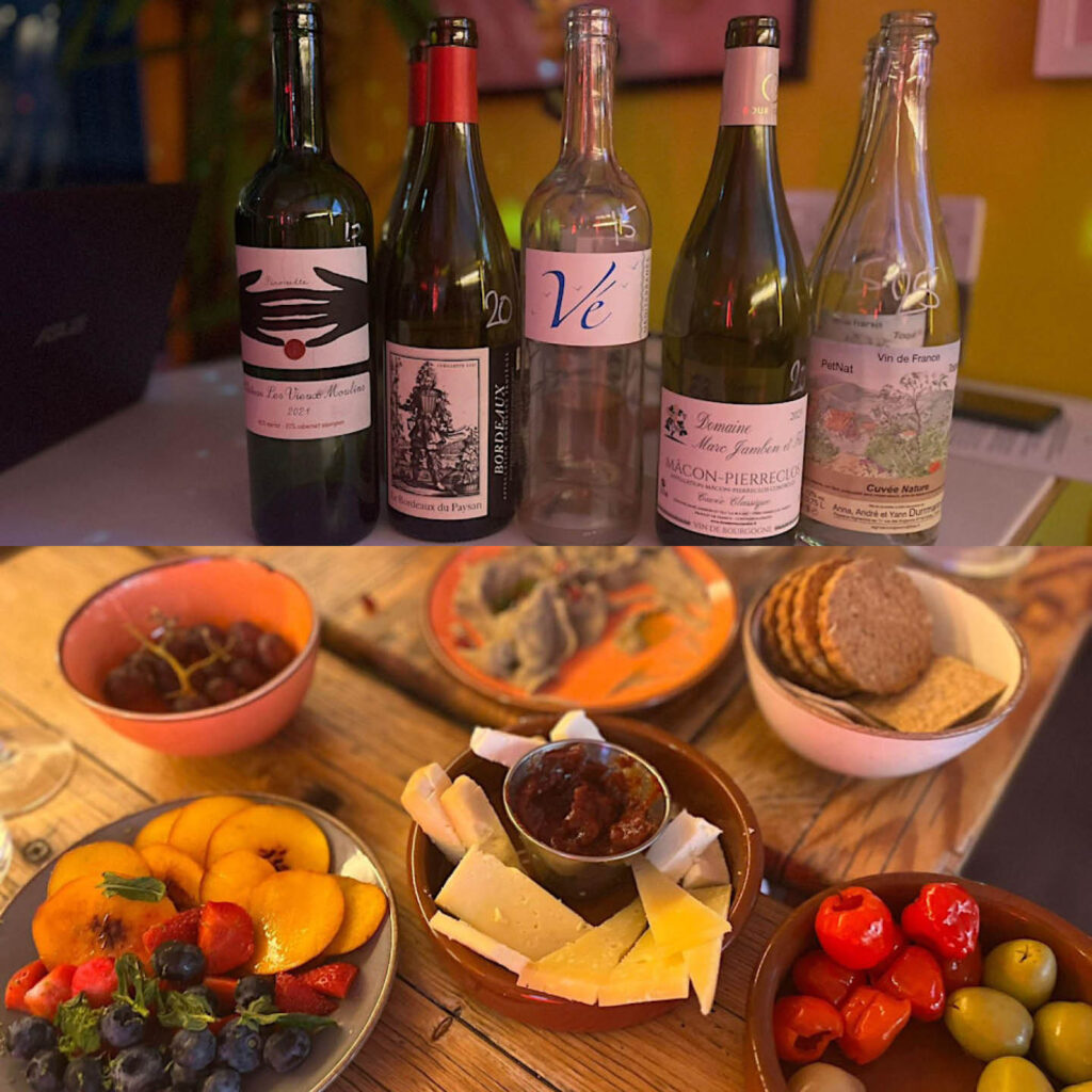 Five bottles of different wines lined up in a row. Below this image, a wooden table is laid with crackers, olives and other nibbles. These photos are taken at the North East Wine Tasting sessions at Ernest.