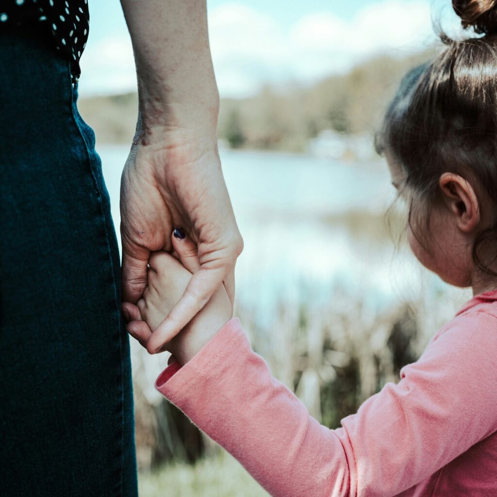 A child holds their mother's hand