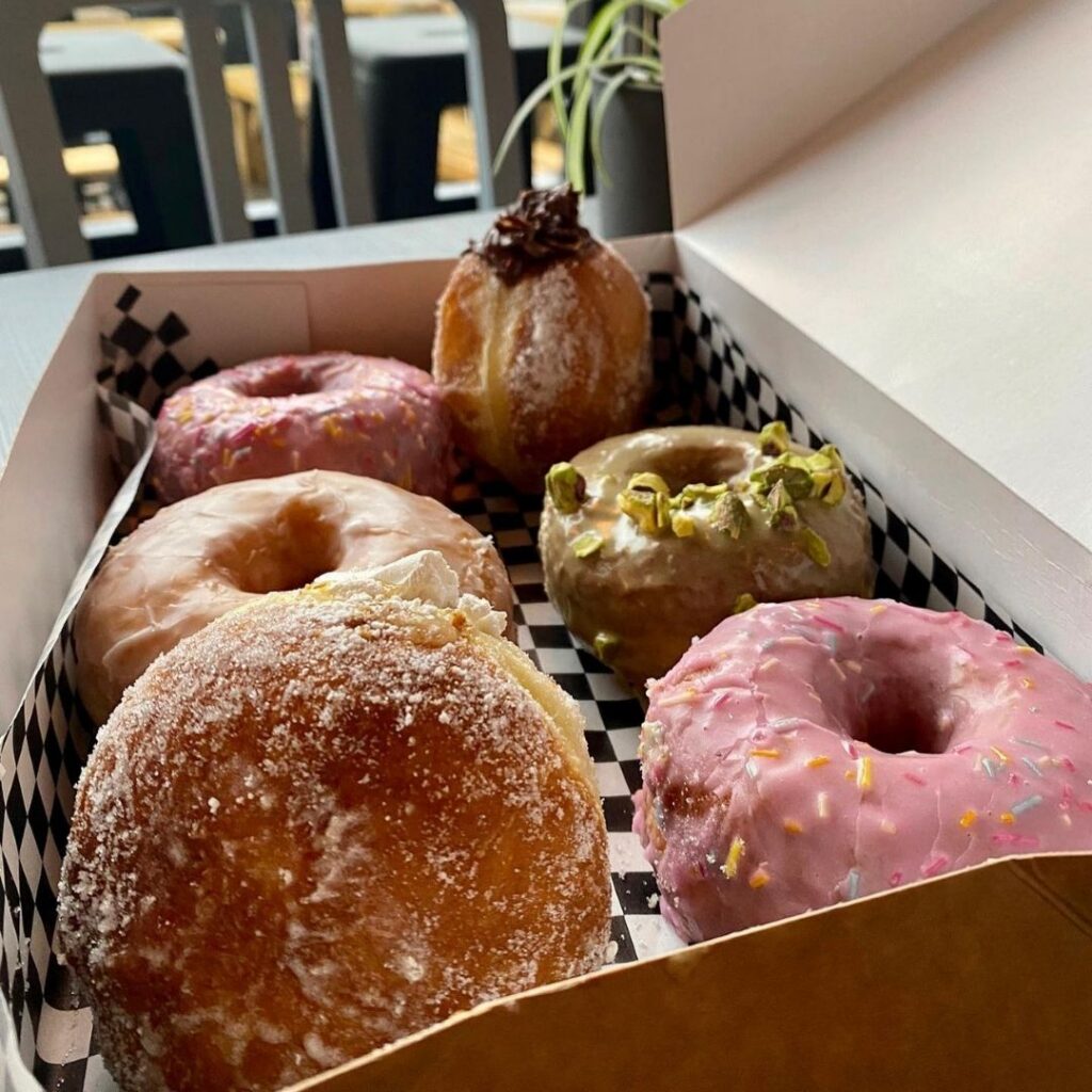 six different donuts in a checkered box from Deep North located in Ouseburn