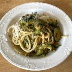 A bowl of creamy courgette, pine nut and lemon linguine topped with freshly grated parmesan. Thinly sliced courgettes are cooked until soft and silky, creating a light, creamy sauce without cream.