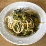 A bowl of creamy courgette, pine nut and lemon linguine topped with freshly grated parmesan. Thinly sliced courgettes are cooked until soft and silky, creating a light, creamy sauce without cream.